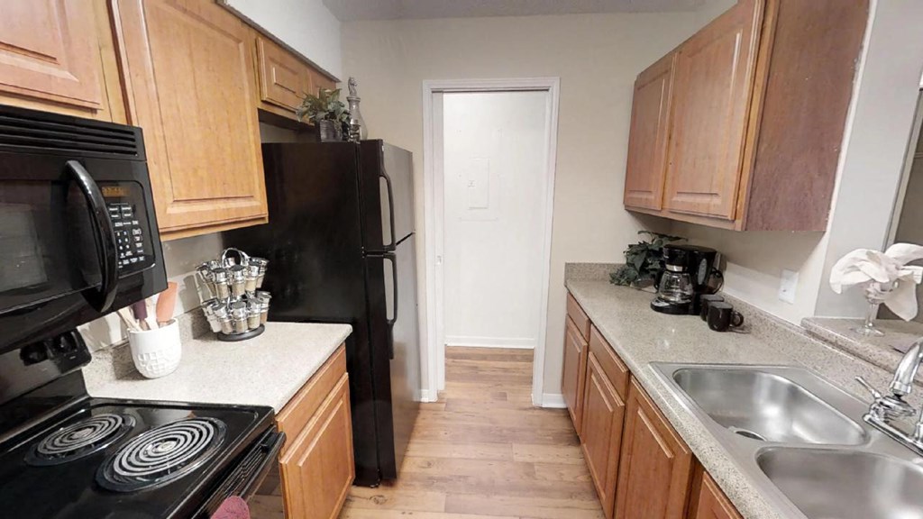 a kitchen with wooden cabinets and a black refrigerator